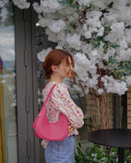 Selena pink vegan leather hobo bag worn on shoulder